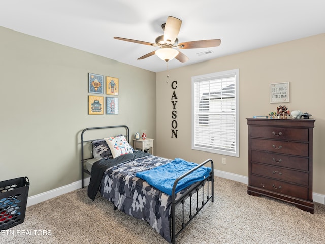 bedroom with ceiling fan, light colored carpet, visible vents, and baseboards