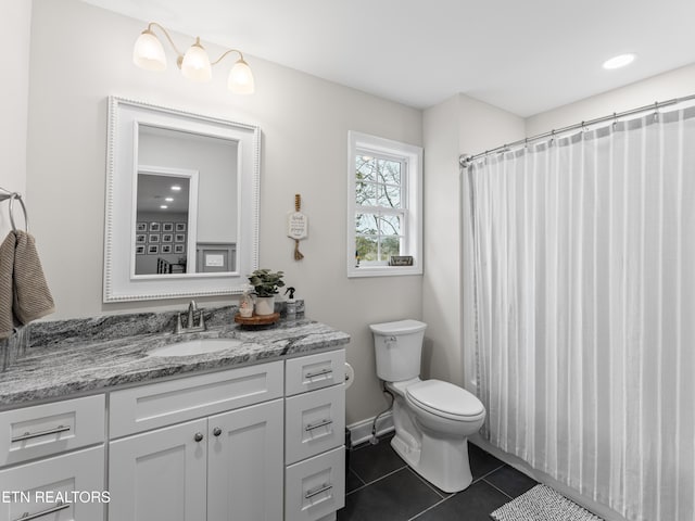 full bath featuring toilet, vanity, and tile patterned flooring