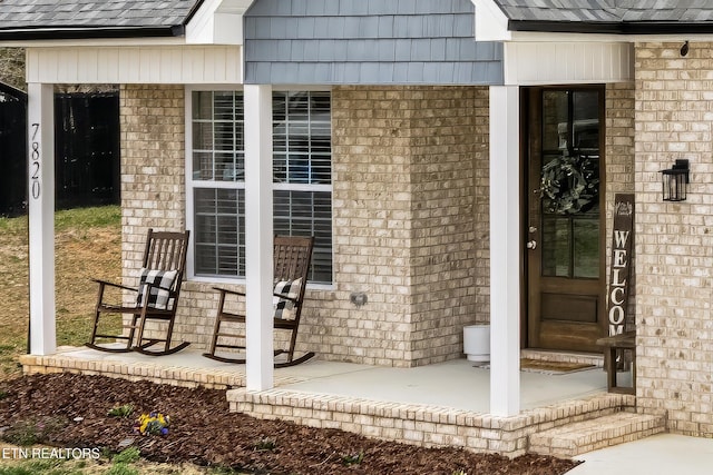 property entrance with a shingled roof