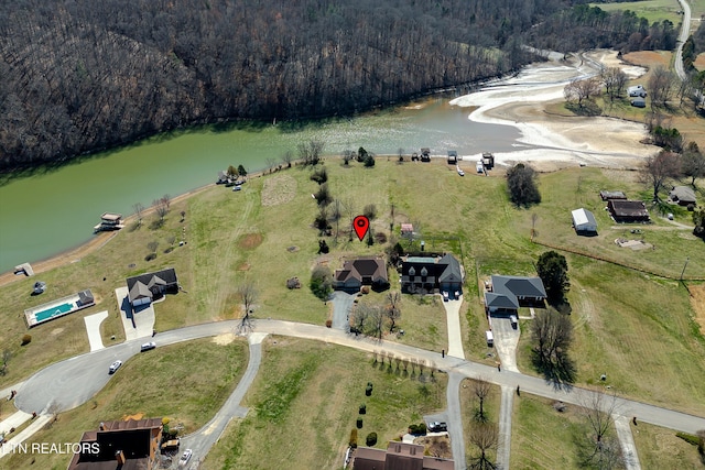 drone / aerial view with a forest view and a water view