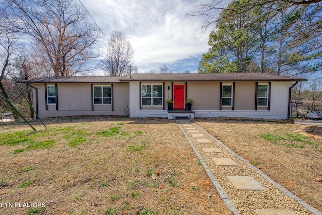 single story home with brick siding and a front yard