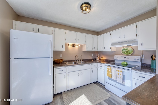 kitchen featuring under cabinet range hood, white cabinets, white appliances, and a sink