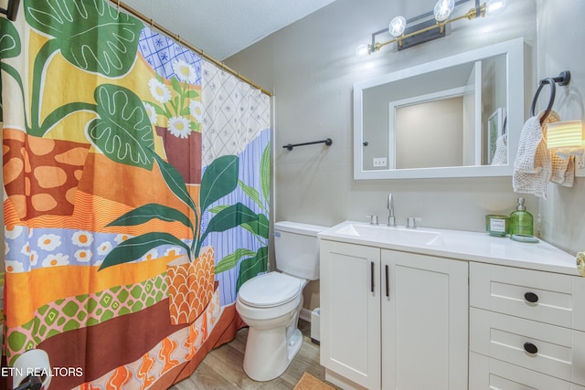 full bathroom with vanity, wood finished floors, a textured ceiling, curtained shower, and toilet