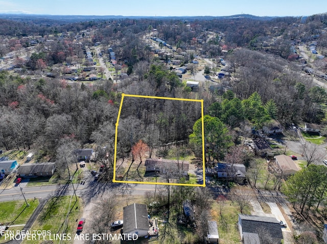 birds eye view of property featuring a wooded view