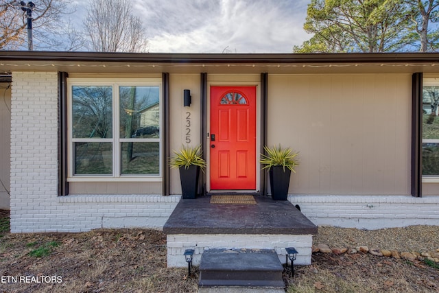 doorway to property with brick siding