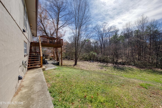 view of yard featuring a wooden deck and stairs