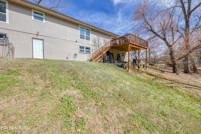 rear view of property with stairway, a yard, and a deck