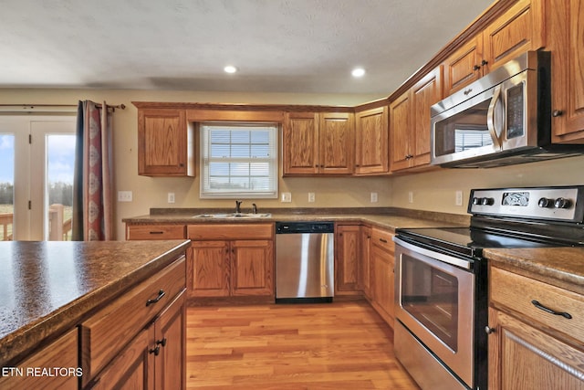 kitchen featuring brown cabinets, appliances with stainless steel finishes, and a sink