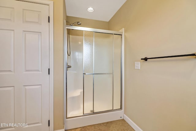 bathroom featuring tile patterned floors, baseboards, and a stall shower