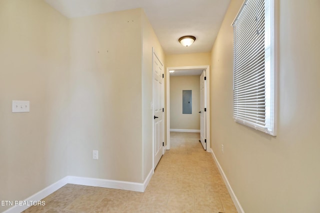 corridor featuring electric panel and baseboards