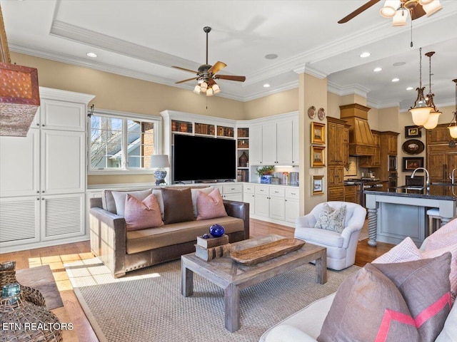 living room with recessed lighting, light wood-style flooring, a ceiling fan, and ornamental molding