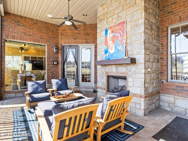 view of patio / terrace featuring a ceiling fan and an outdoor living space with a fireplace