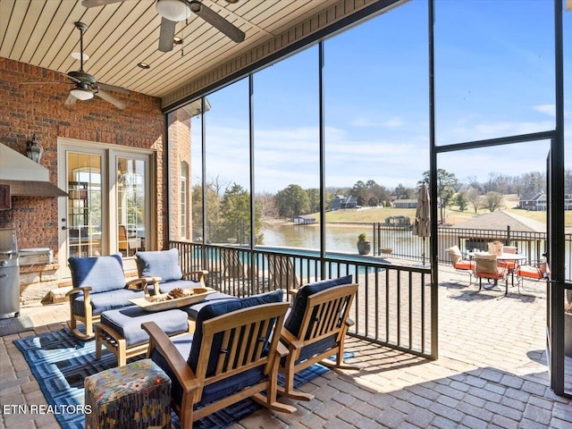 sunroom featuring plenty of natural light, a water view, and ceiling fan