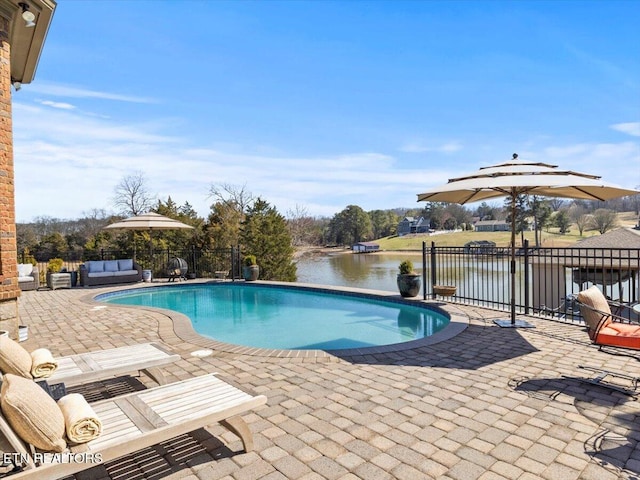 view of swimming pool with a fenced in pool, fence, a water view, outdoor lounge area, and a patio area