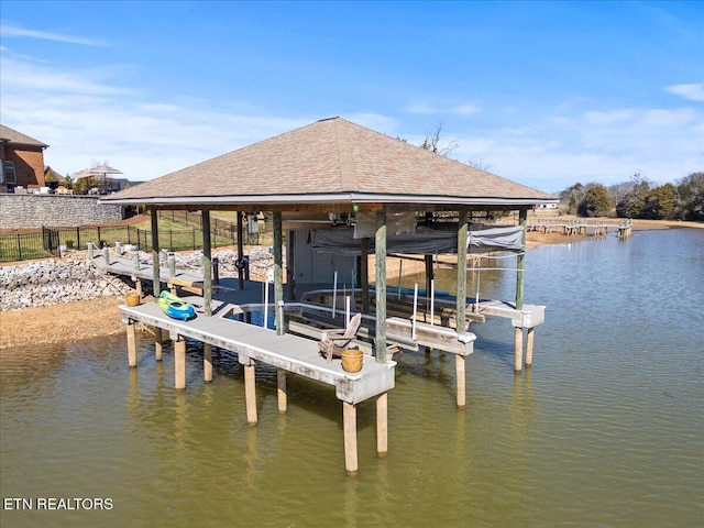 view of dock with fence, a water view, and boat lift