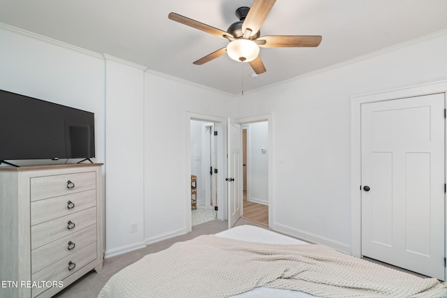 bedroom with a ceiling fan, baseboards, light colored carpet, and crown molding