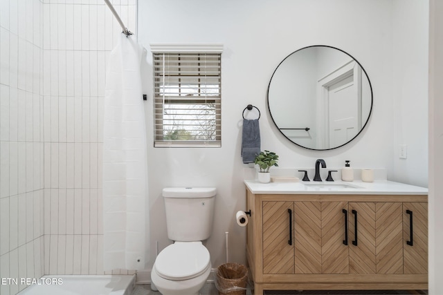 bathroom with vanity, toilet, and a tile shower