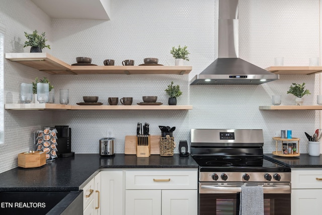 kitchen with open shelves, wall chimney range hood, stainless steel electric stove, and tasteful backsplash