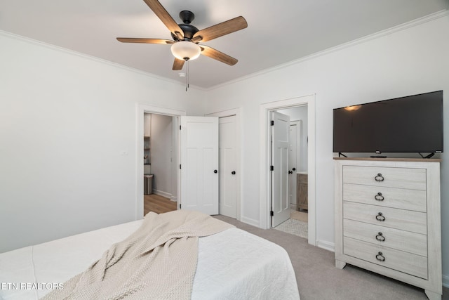 bedroom featuring crown molding, baseboards, ceiling fan, light colored carpet, and ensuite bath