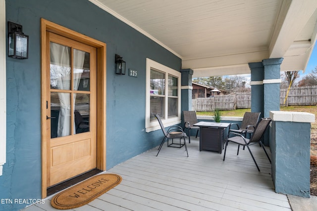 deck featuring a porch and fence