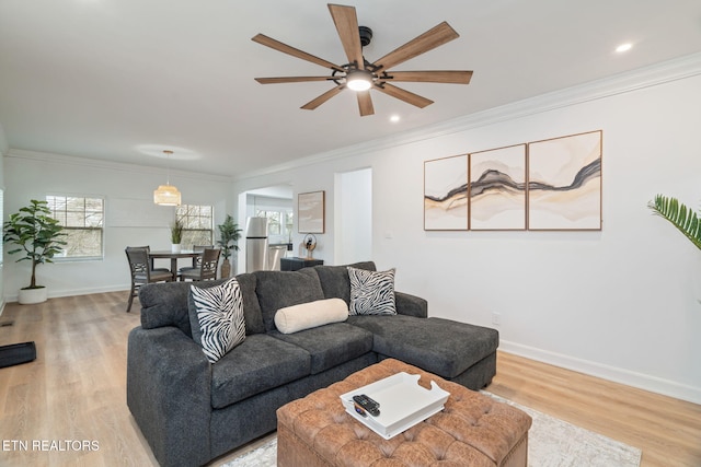 living room featuring baseboards, recessed lighting, ceiling fan, light wood-style floors, and crown molding