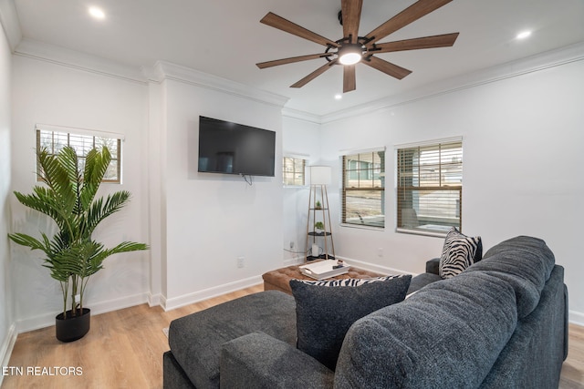 living area with light wood-style flooring, a wealth of natural light, and ornamental molding