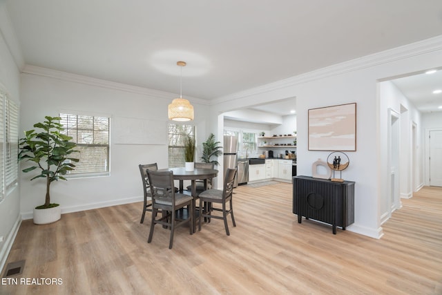 dining area with ornamental molding, baseboards, visible vents, and light wood-type flooring