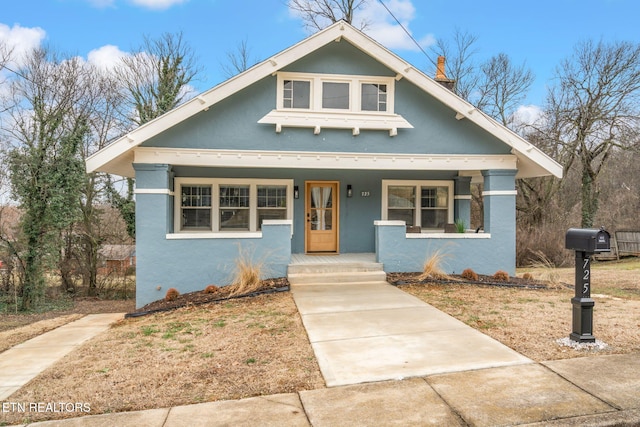 bungalow-style house featuring stucco siding and a porch