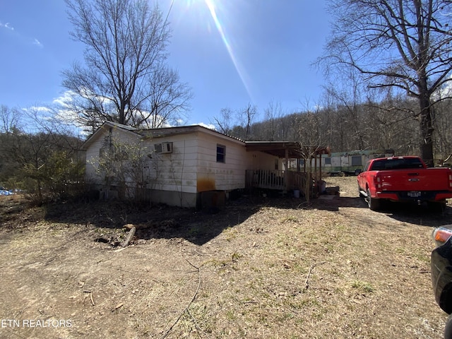 view of property exterior with an AC wall unit