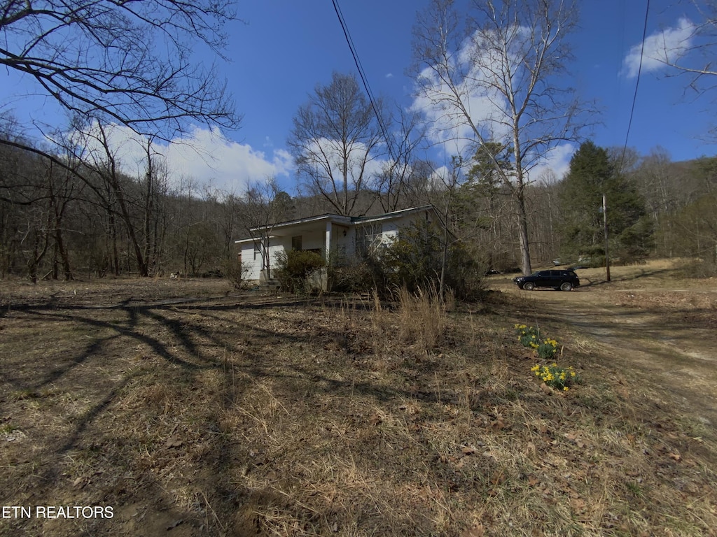 view of side of property with a forest view