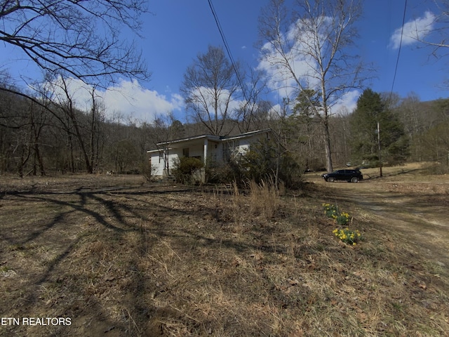 view of side of property with a forest view