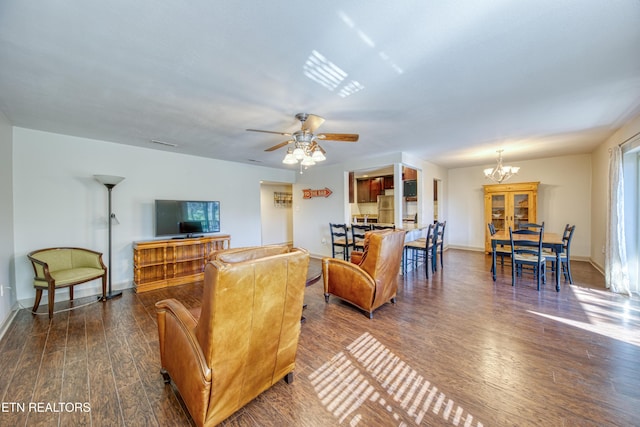 living area with ceiling fan with notable chandelier, baseboards, and wood finished floors