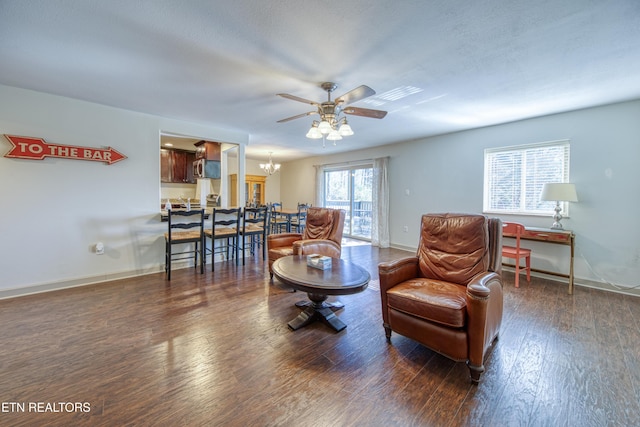 living room featuring baseboards, hardwood / wood-style floors, and ceiling fan with notable chandelier