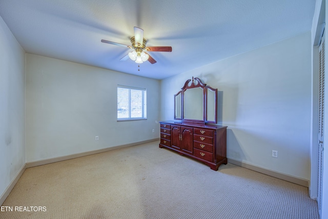 unfurnished bedroom with carpet flooring, baseboards, and ceiling fan