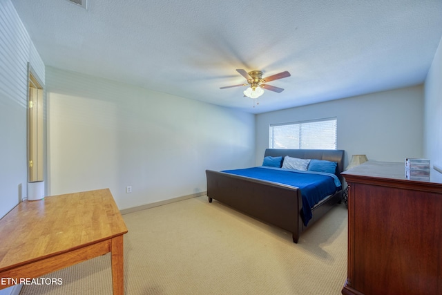 bedroom with carpet, a ceiling fan, and a textured ceiling