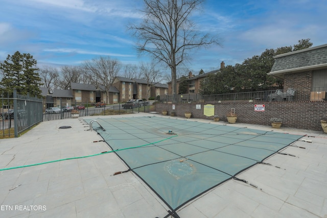 pool featuring a patio area, fence, and a residential view