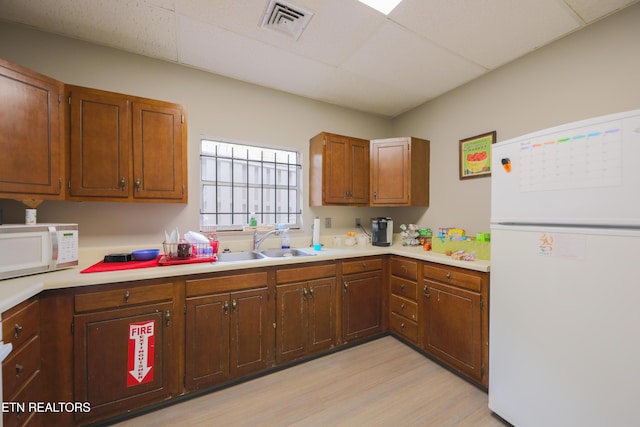 kitchen featuring a drop ceiling, visible vents, white appliances, and light countertops