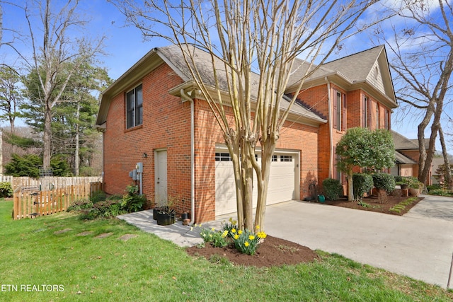 traditional-style house with fence, concrete driveway, a front yard, a garage, and brick siding