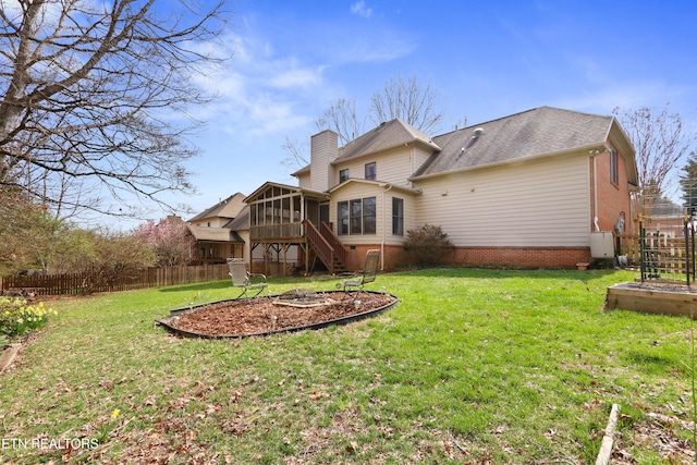 back of house featuring a fire pit, fence, stairs, a chimney, and a sunroom