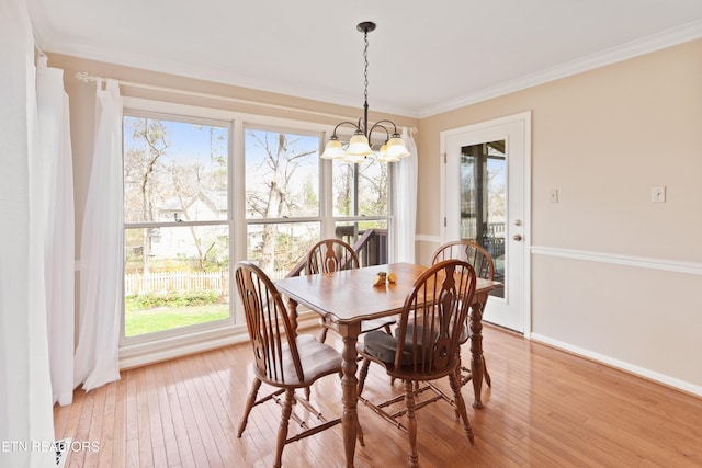 dining area with light wood-style floors, baseboards, a chandelier, and ornamental molding