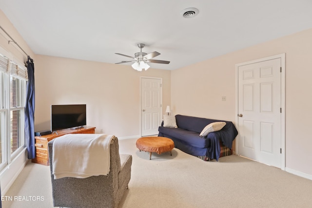 living area featuring visible vents, a ceiling fan, baseboards, and carpet floors