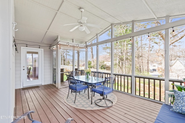 unfurnished sunroom featuring ceiling fan and vaulted ceiling