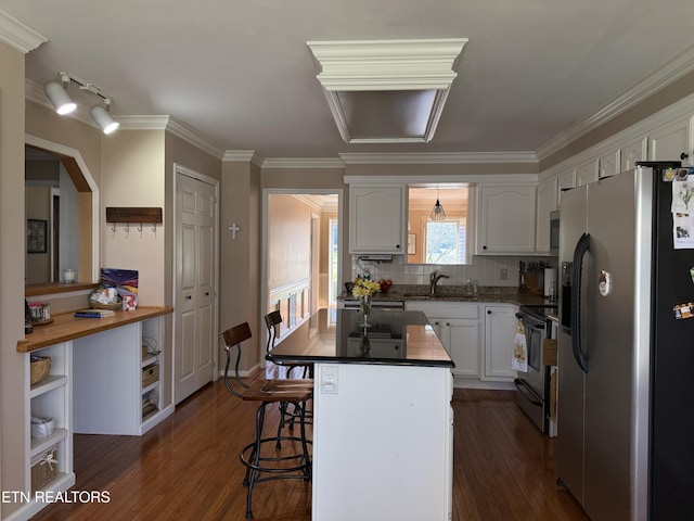 kitchen with dark wood-style floors, appliances with stainless steel finishes, white cabinetry, and a sink