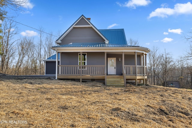 view of front of property featuring crawl space, metal roof, and a porch