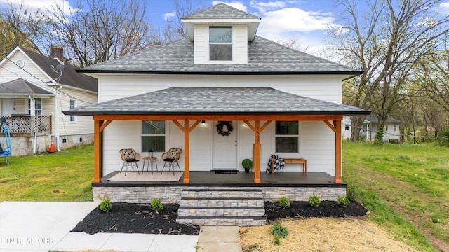 view of front of property with a front yard, a gazebo, and roof with shingles
