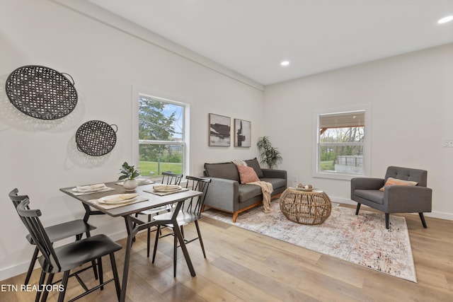 dining room with baseboards, light wood-style floors, recessed lighting, and a healthy amount of sunlight