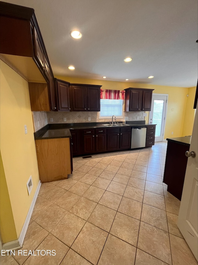 kitchen with a sink, dark countertops, light tile patterned floors, decorative backsplash, and dishwasher