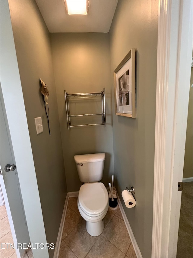 bathroom featuring tile patterned floors, toilet, and baseboards