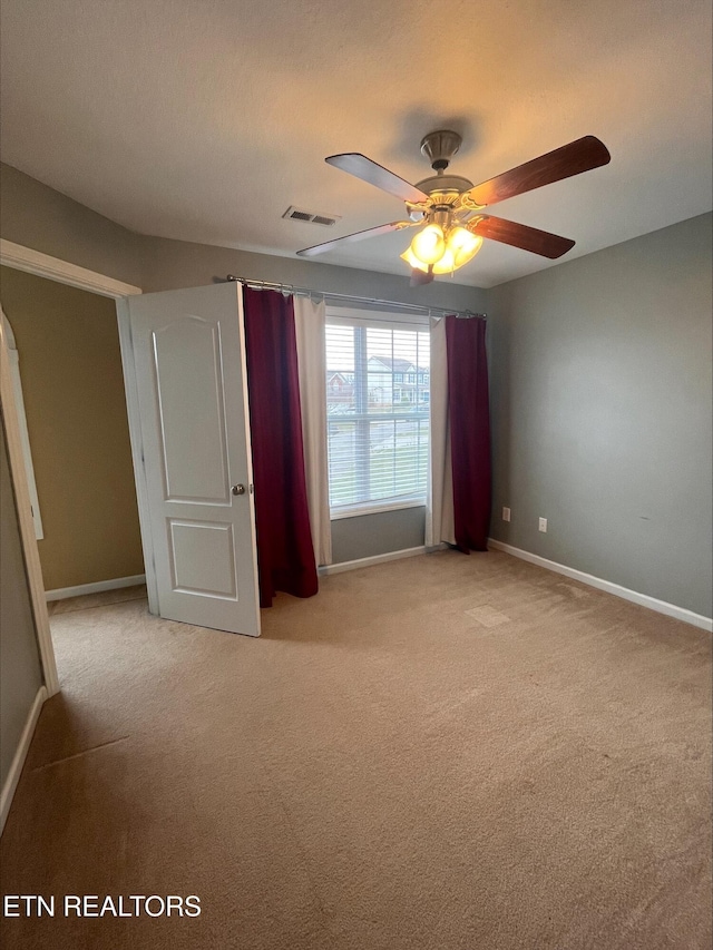 unfurnished bedroom featuring visible vents, light carpet, and baseboards