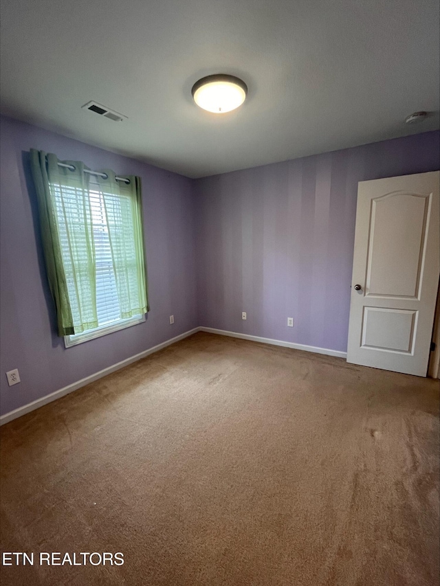 carpeted empty room with visible vents and baseboards